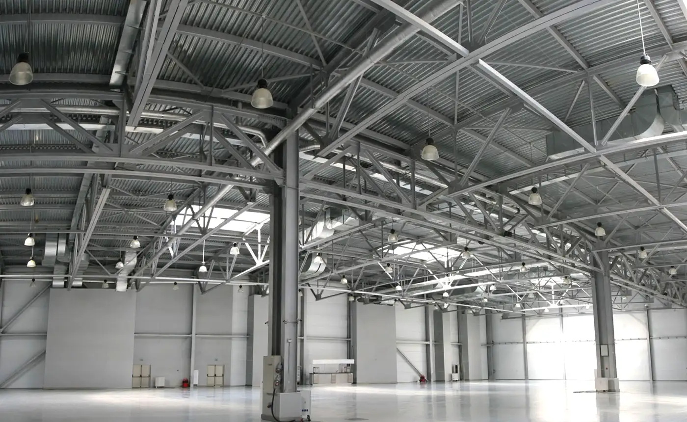 Spacious industrial warehouse featuring high metal ceilings and ample lighting, showcasing a clean and well-maintained environment ideal for storage or manufacturing. The steel structures uses Nippon Paint Zinc Phosphate Primer FD to protecting the surfaces under non-immersion conditions, providing a reliable base for further coatings.