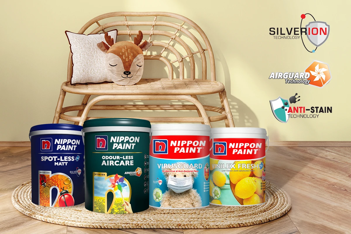 Nippon Paint products displayed in a cozy living space featuring a rattan bench and a decorative pillow. The image showcases Odour-less Aircare, Spot-Less Matt, VirusGuard, and Vinlex Fresh, highlighting advanced technologies like SilverIon, AirGuard, and Anti-Stain for enhanced indoor air quality and protection.
